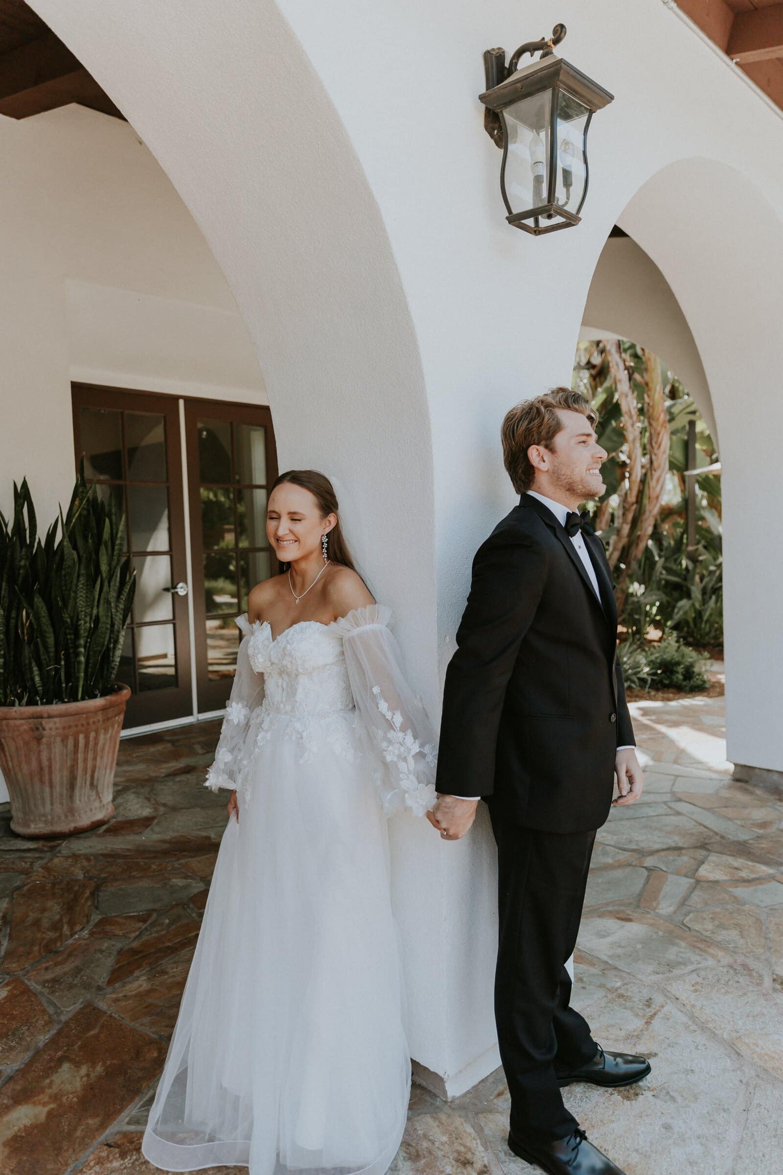 Irelyn and Aleck back to back on either side of an archway before the first look