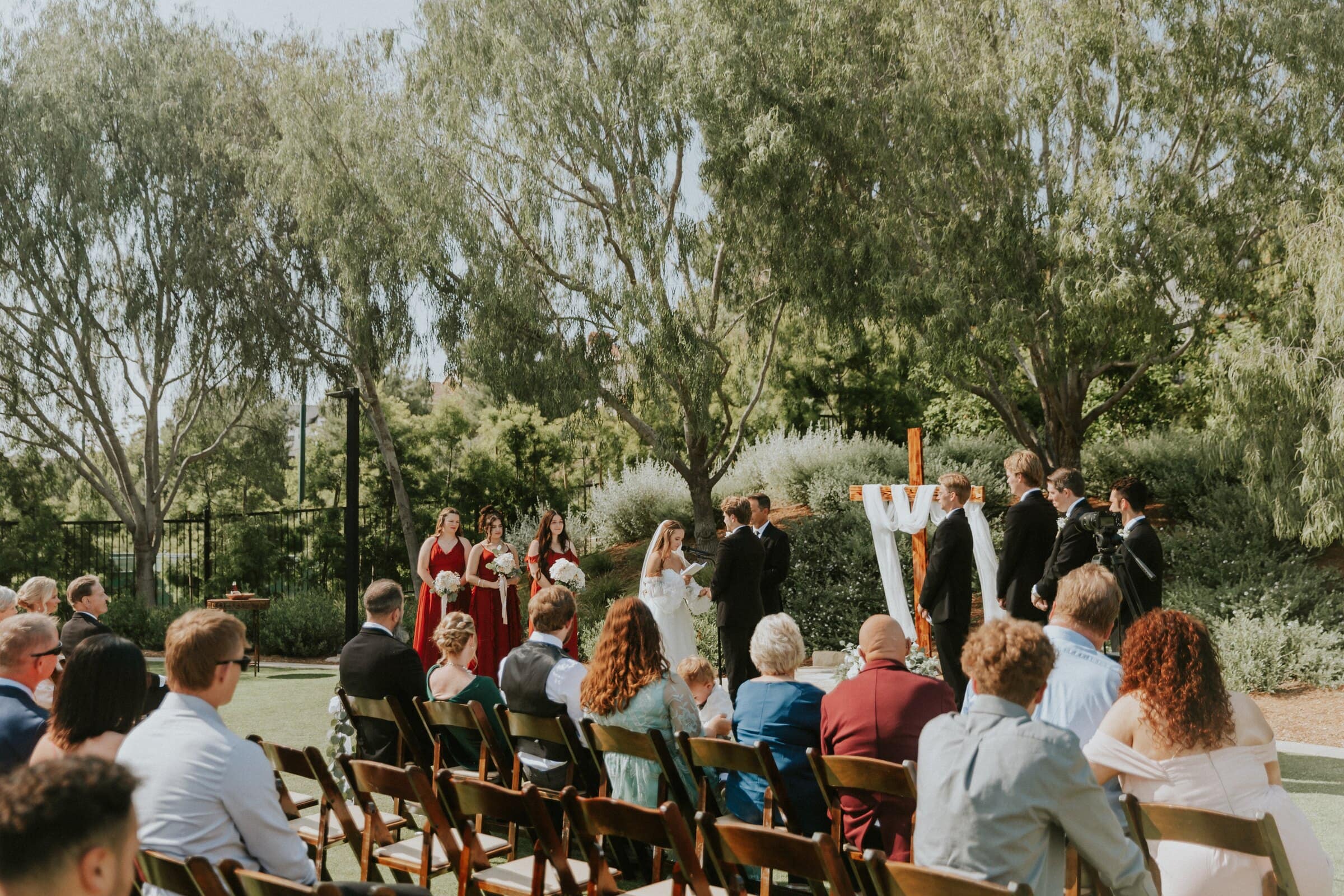 Guests watching the garden ceremony beneath the trees