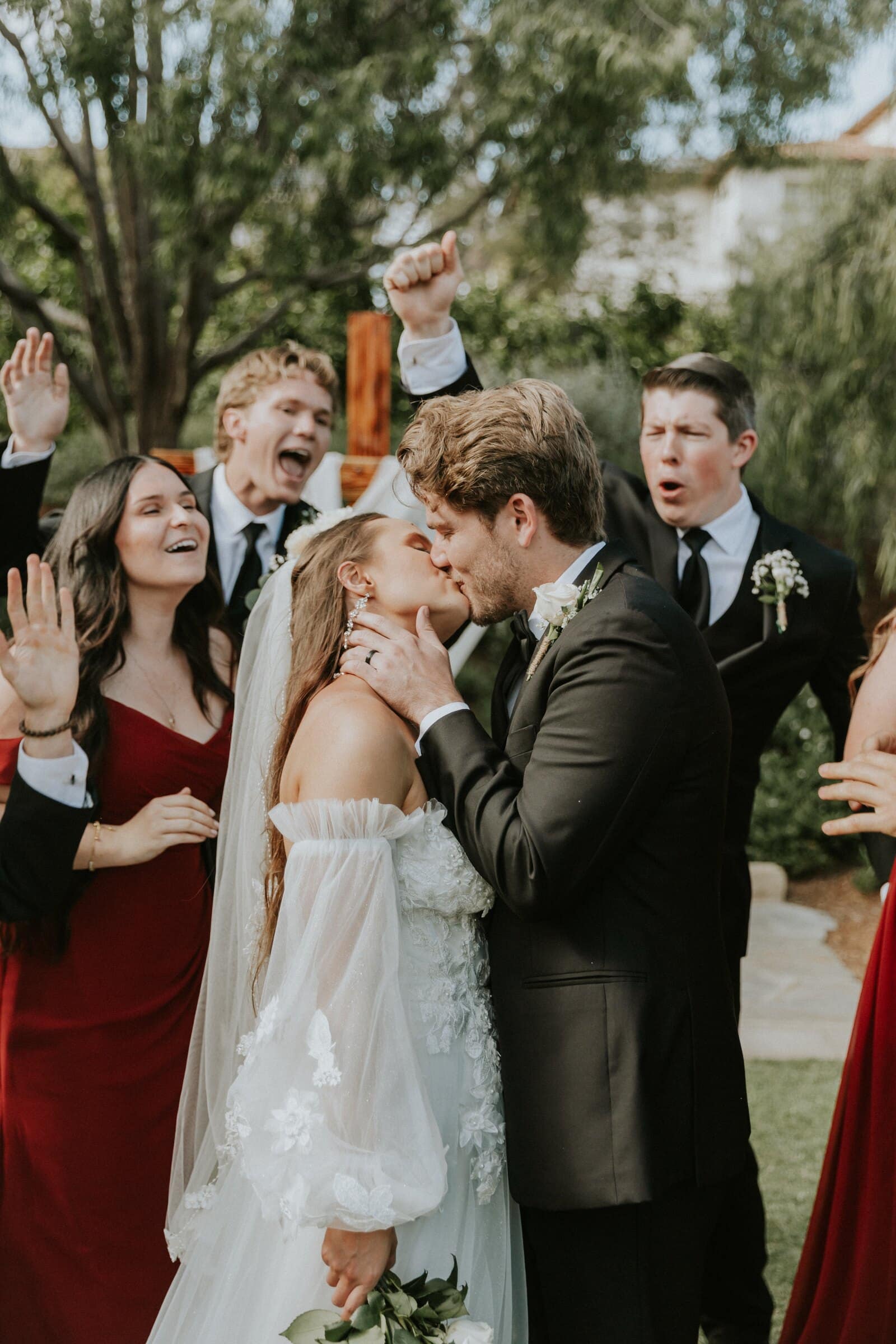 Aleck and Irelyn's kiss as the wedding party cheers