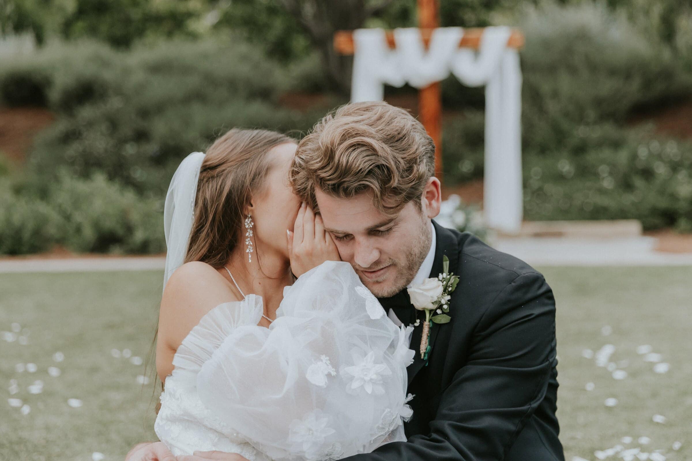 Irelyn whispering to Aleck, her cheek against his