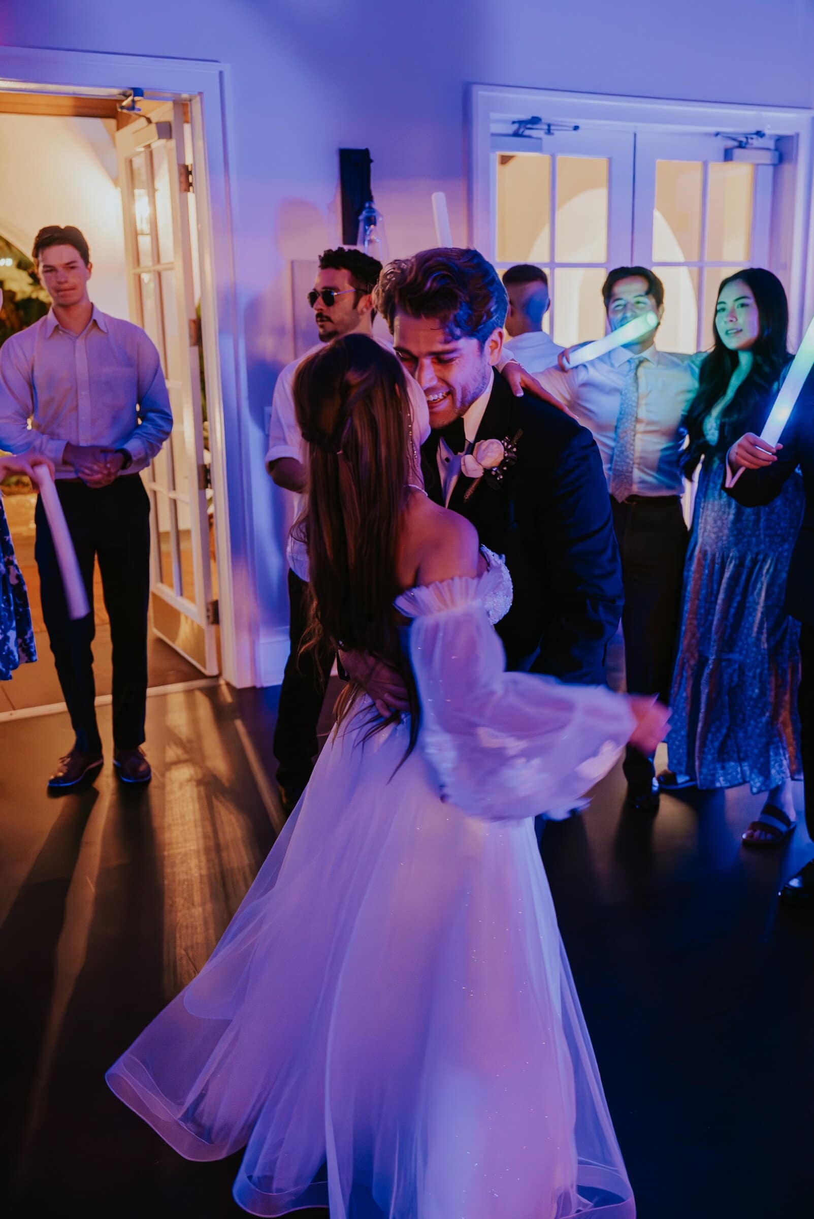 Aleck and Irelyn dancing close, glow sticks shining behind them