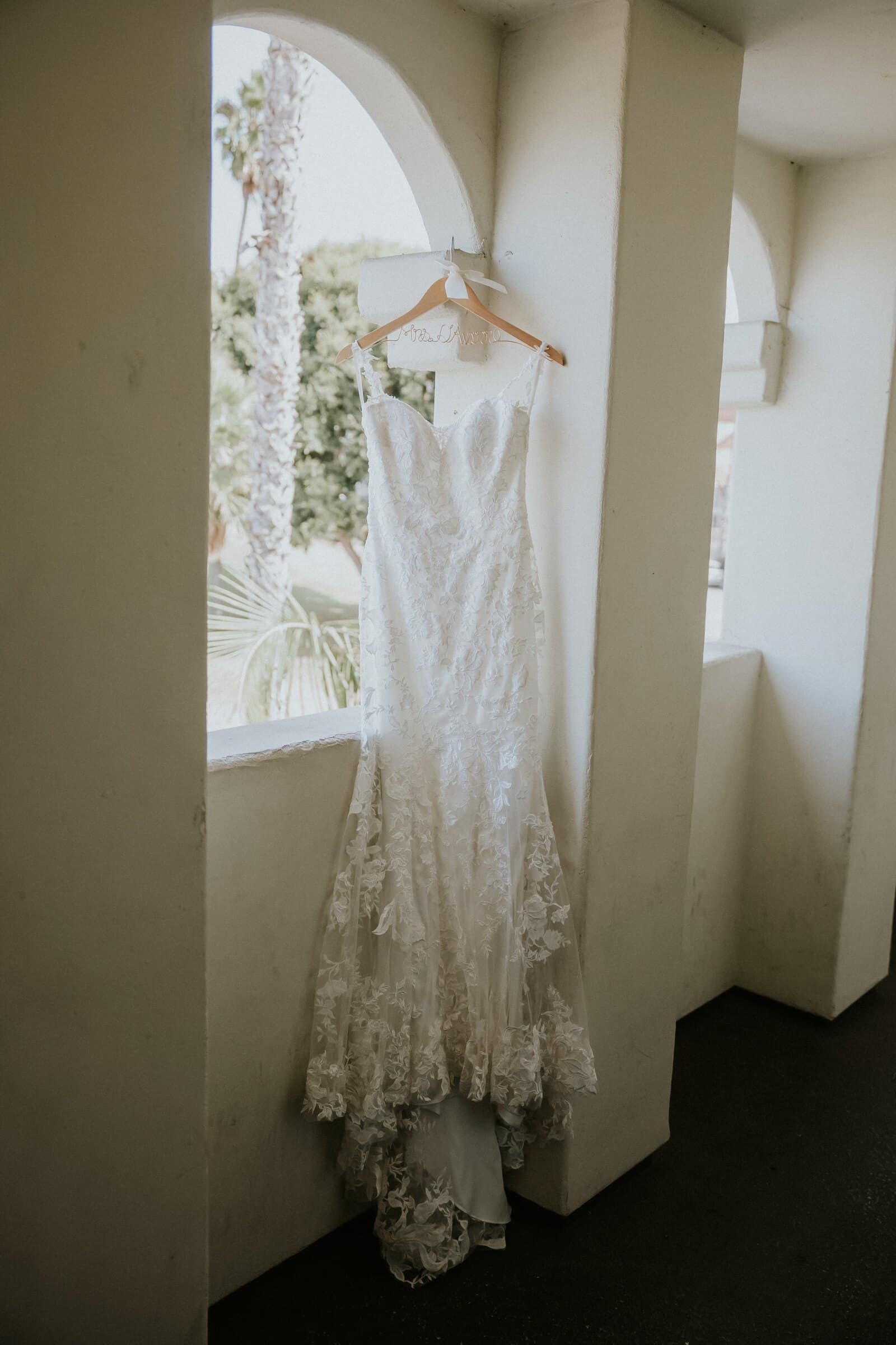 The wedding dress hanging in an arched window