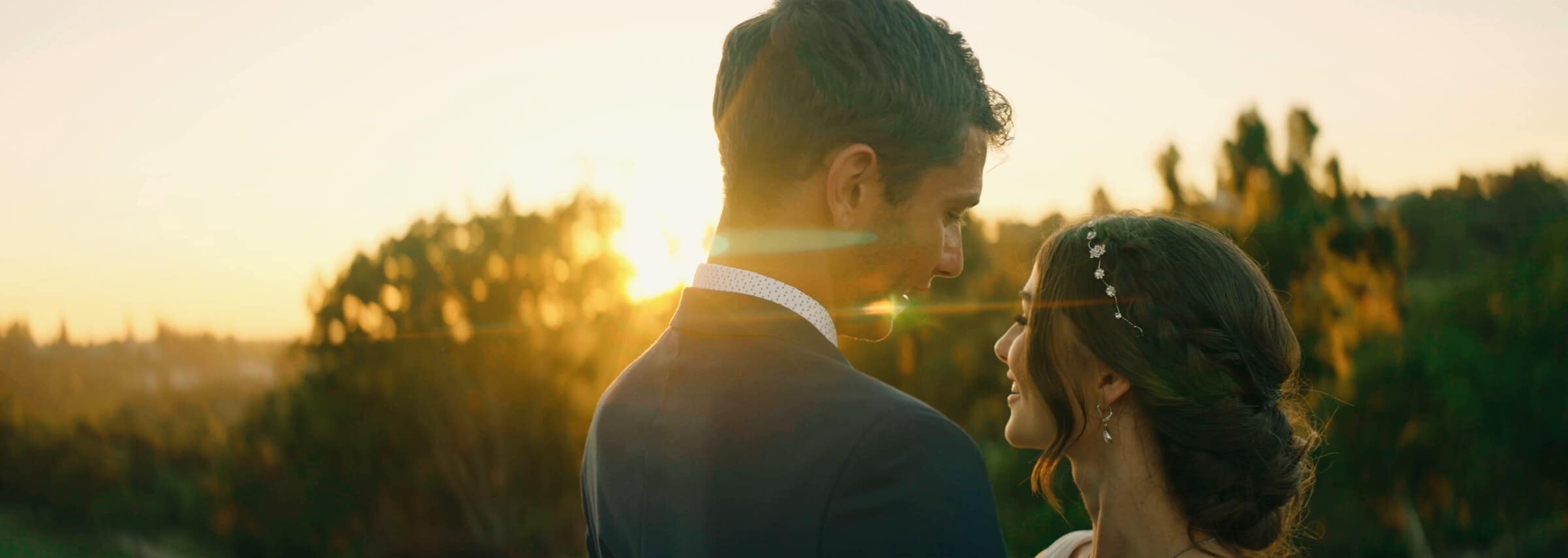 Claire and Bryce face to face as the sun sets behind them