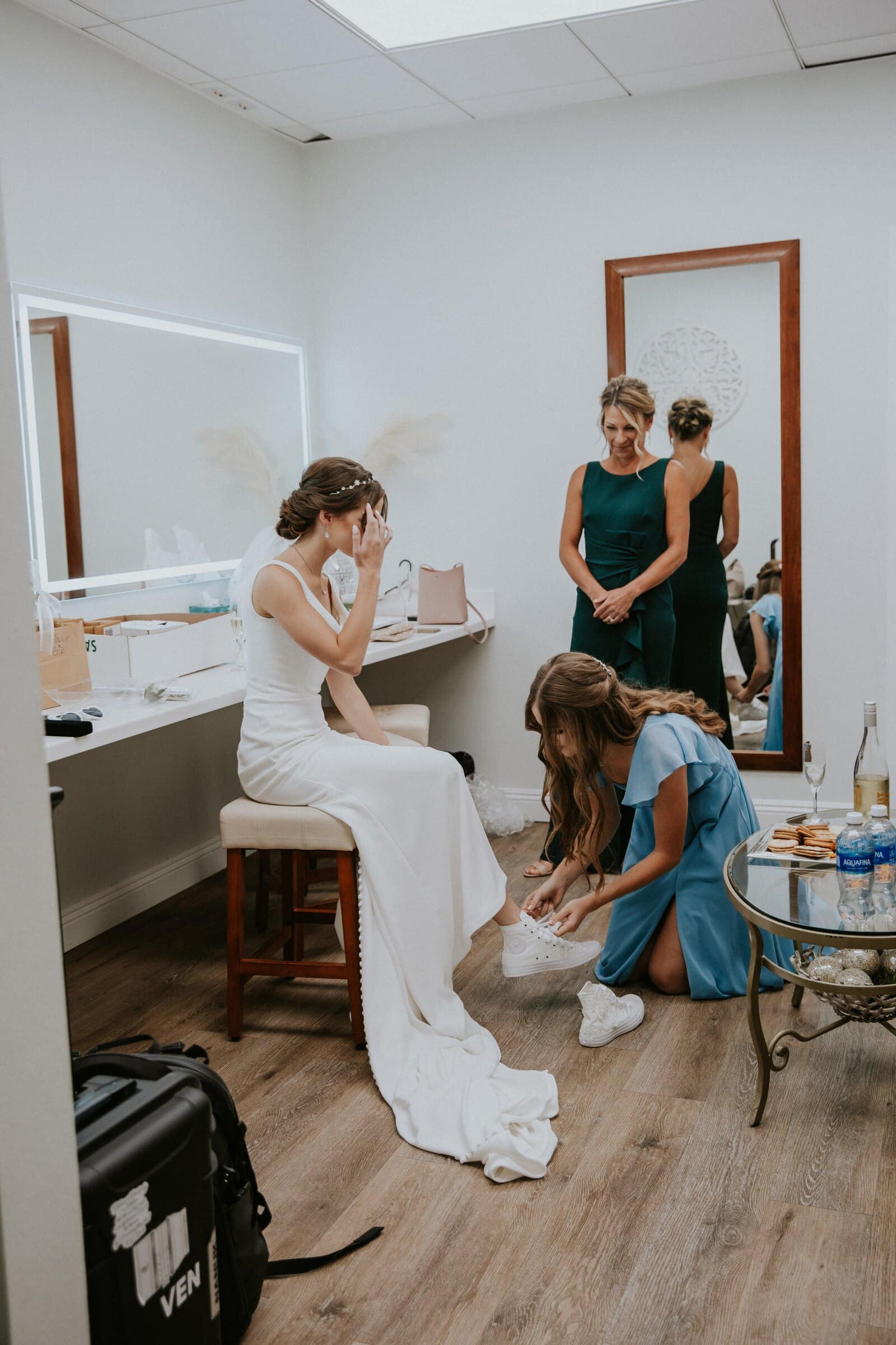 Claire getting ready at a mirror while her bridesmaids help