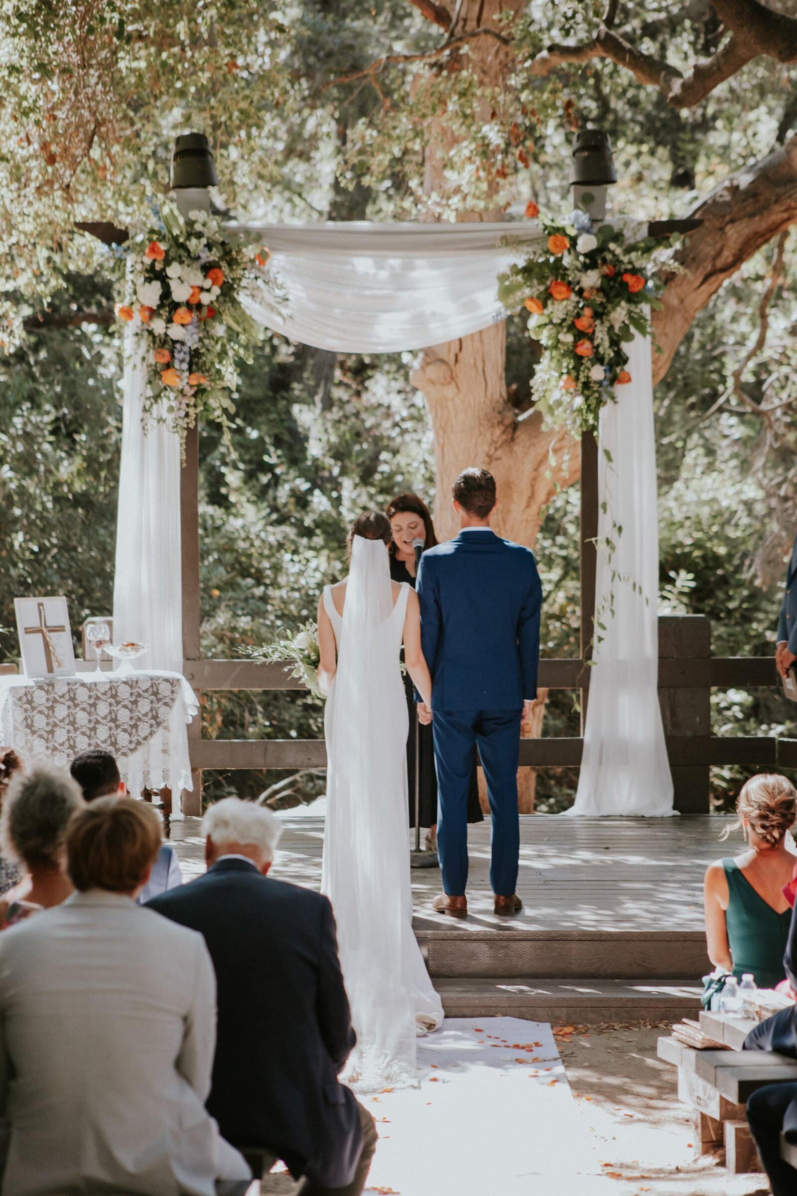 Claire and Bryce facing each other under a white draped arch