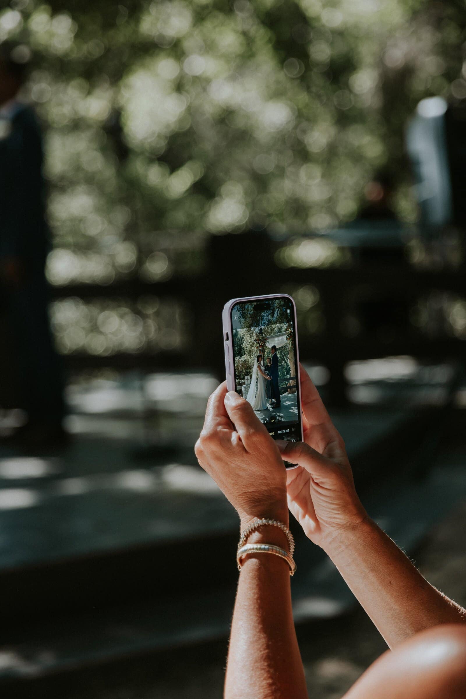 A guest taking a photo of the ceremony on her phone