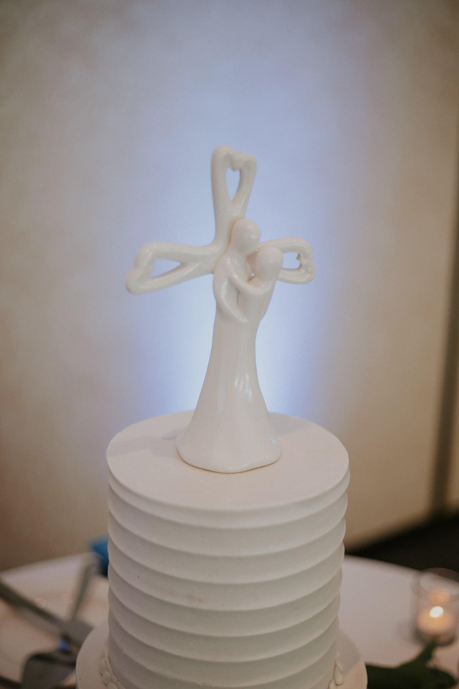 A cross-shaped cake topper on a white cake