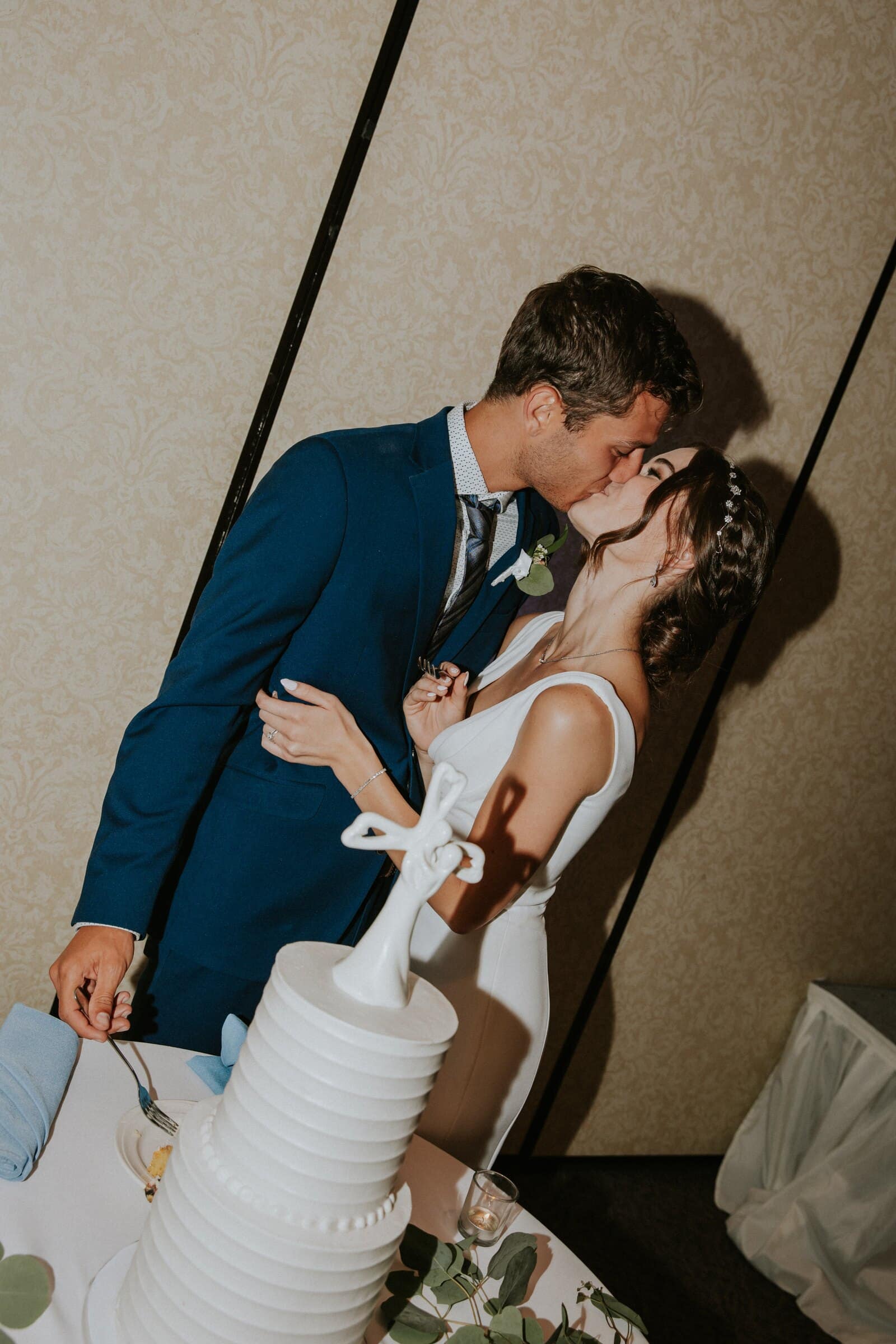 Bryce and Claire kissing beside the cake