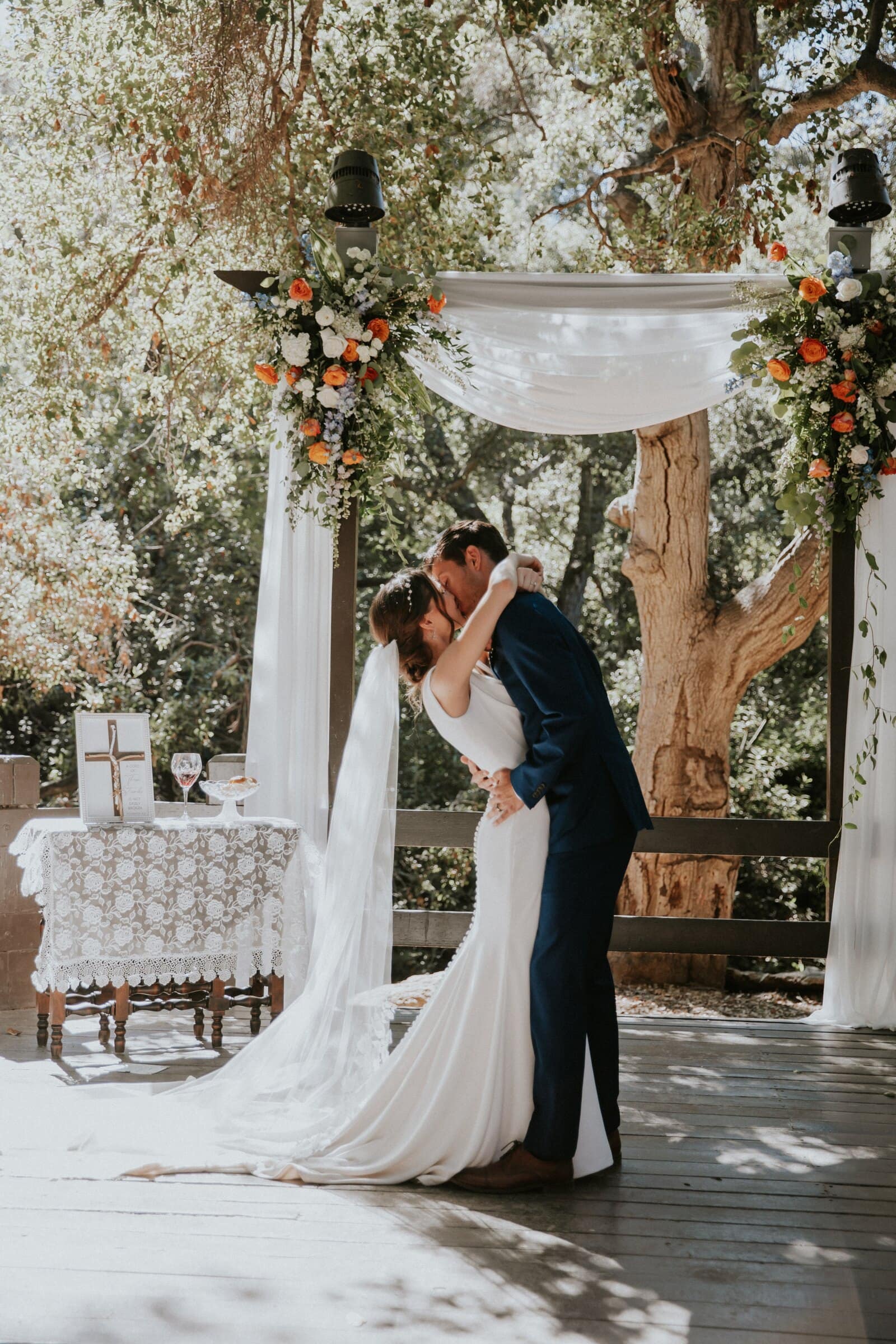 Bryce and Claire's first kiss under the draped arch
