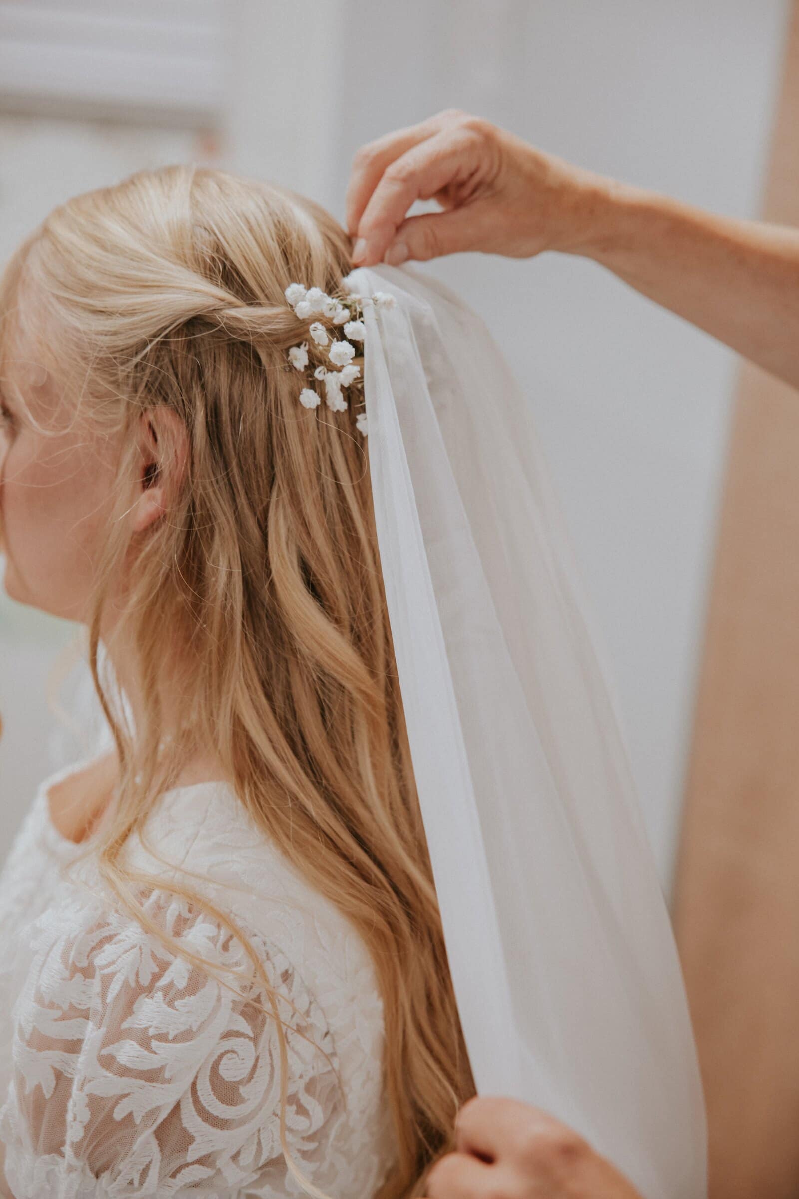 A sprig of baby's breath being pinned into Morgan's hair