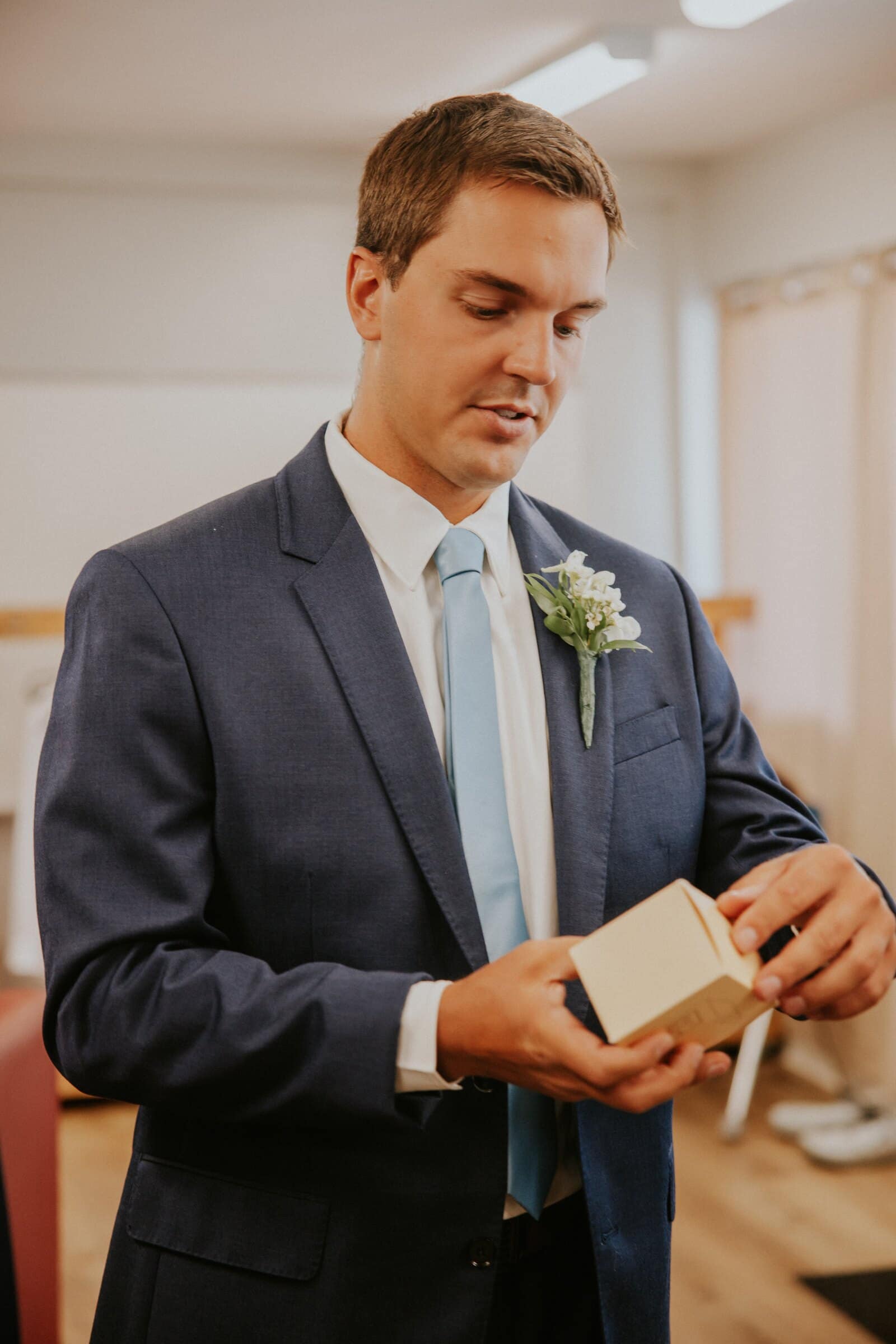 Bryce opening a small gift box before the ceremony