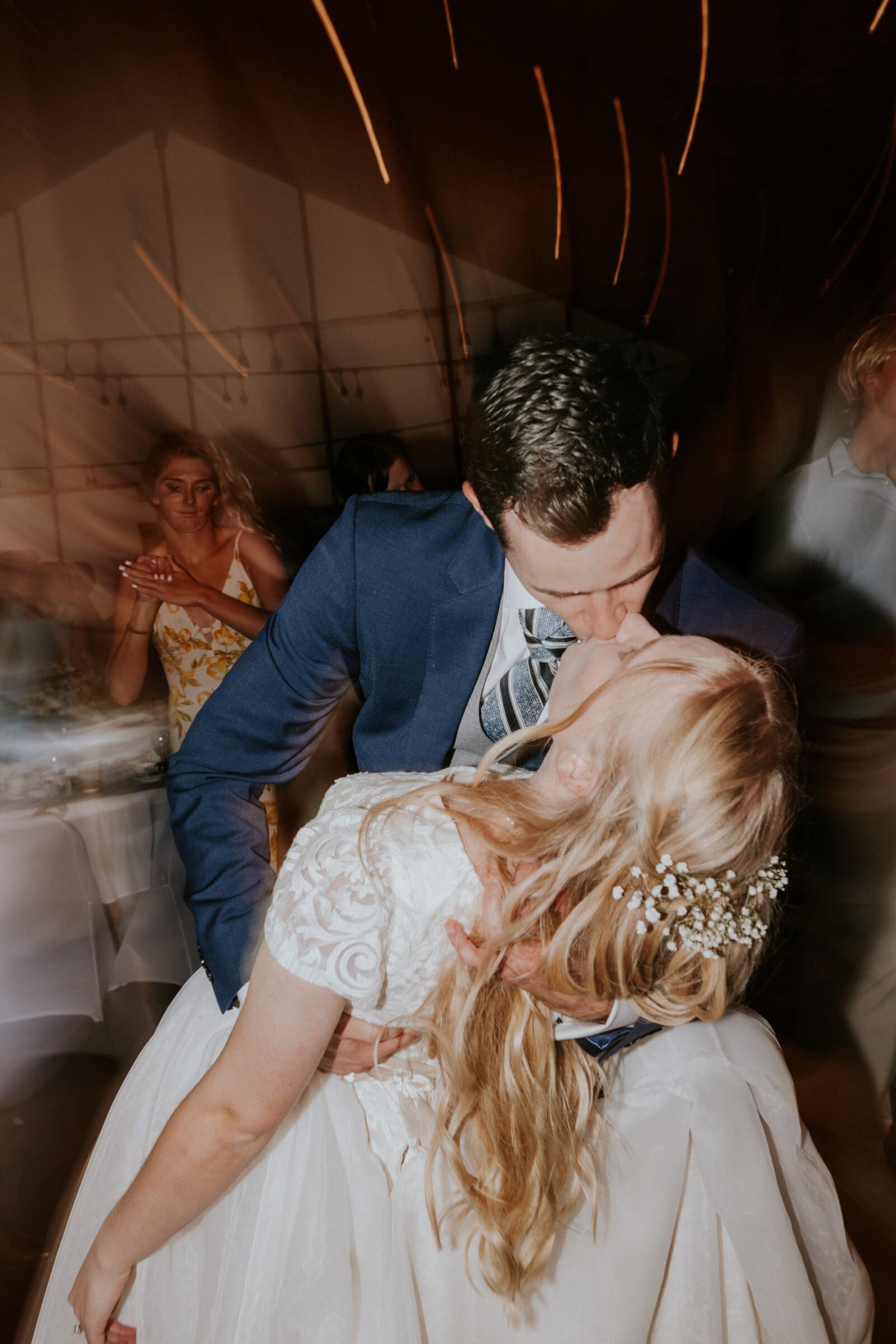 Bryce dipping Morgan for a kiss under streaks of light