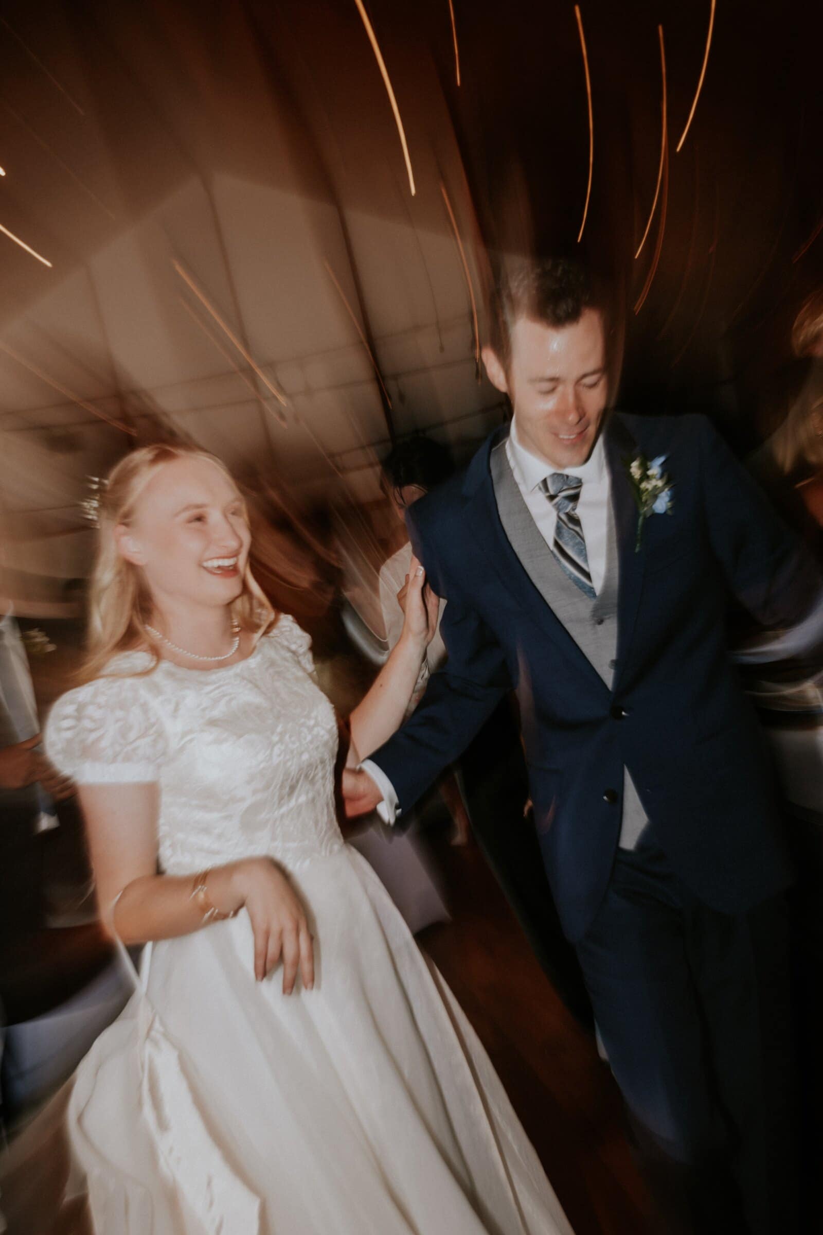 Morgan laughing as she dances with Bryce, the lights streaking overhead