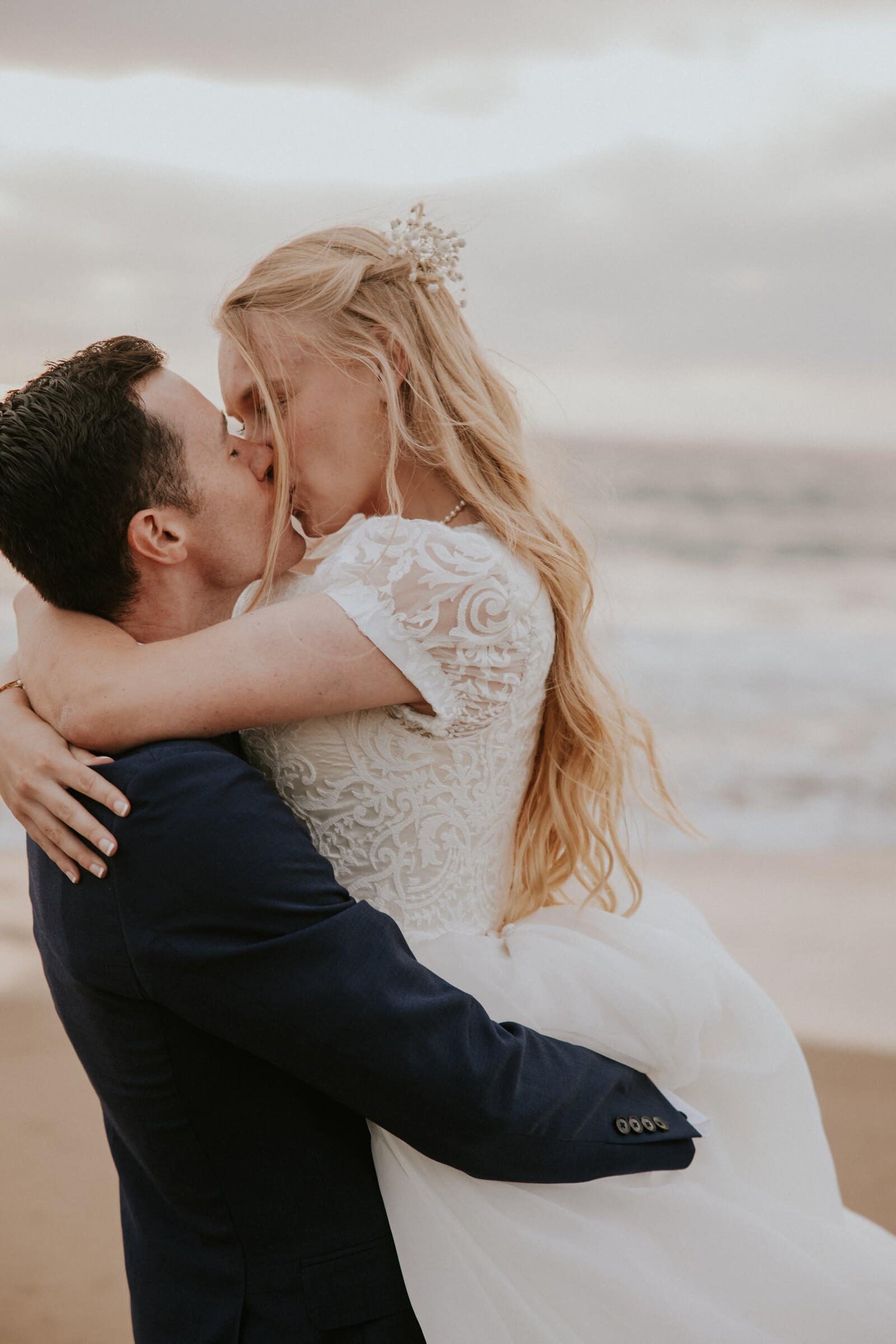 Morgan wrapping her arms around Bryce for a kiss by the water