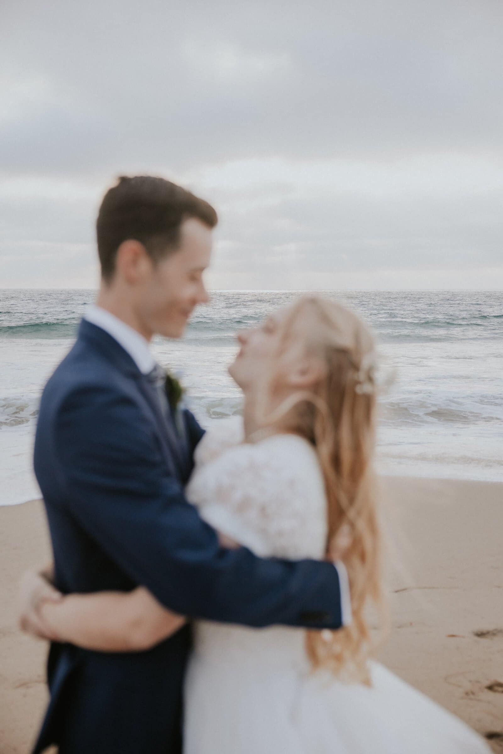 Bryce and Morgan holding each other and smiling on the sand