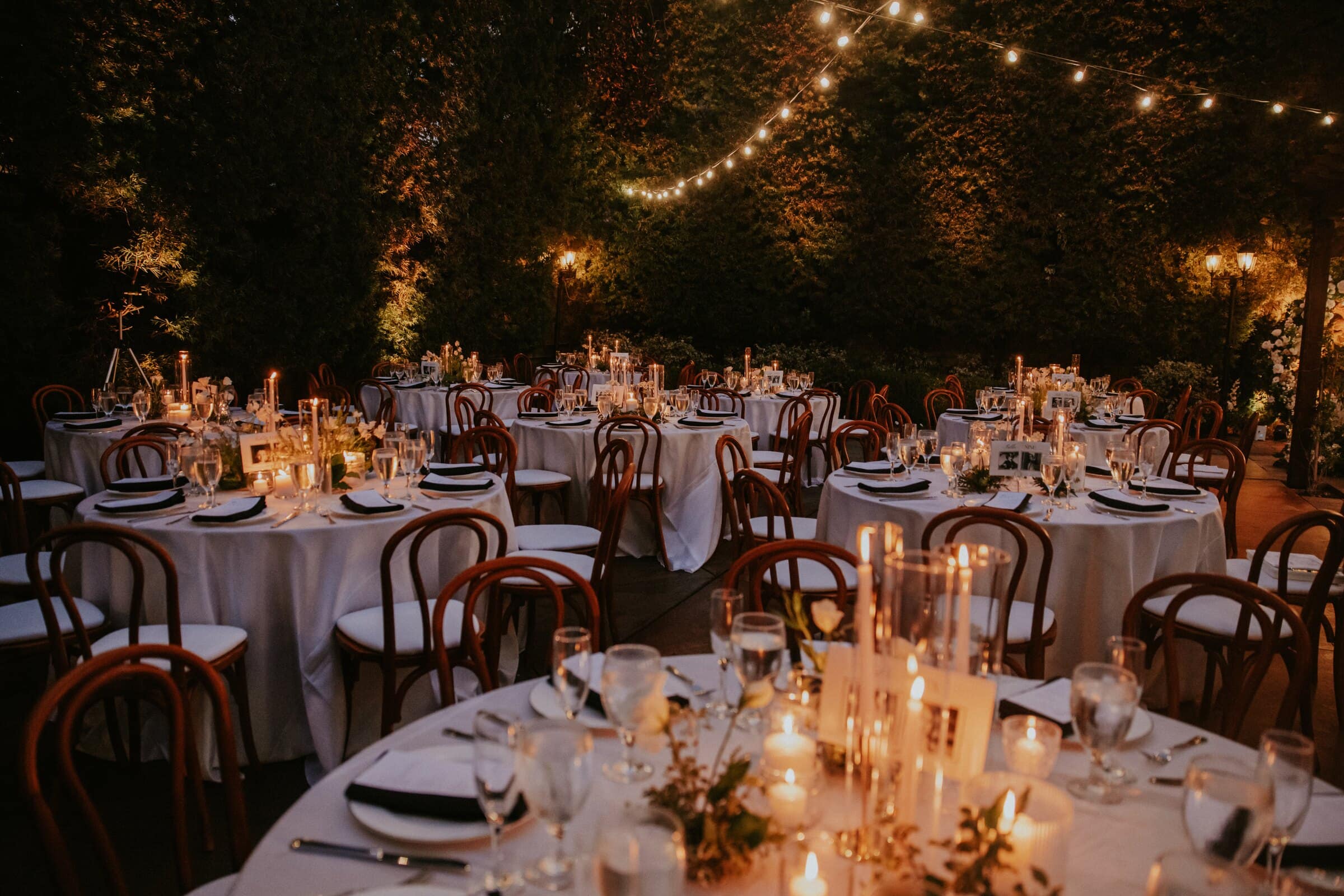 Reception tables set with candles under string lights