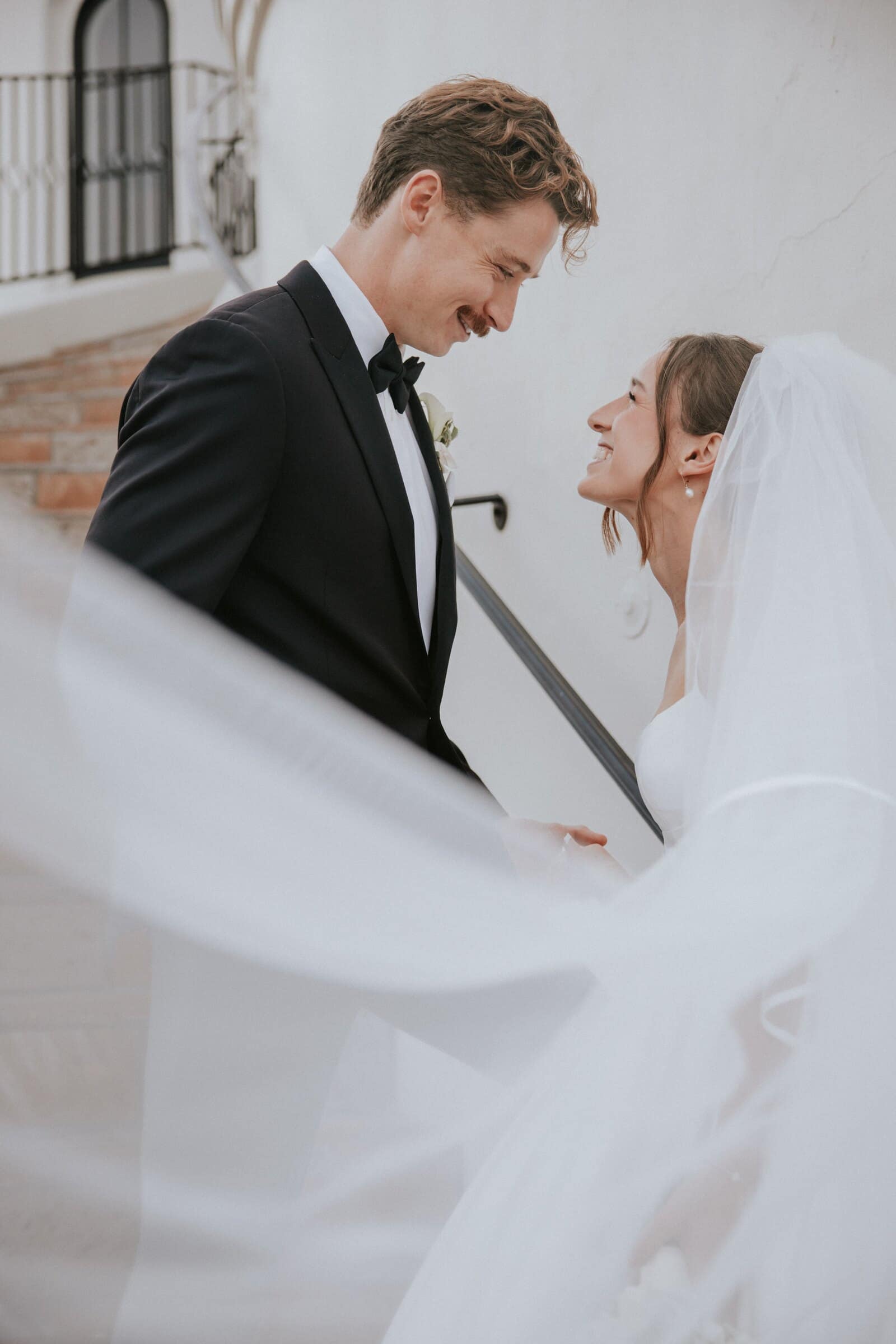 Clara's veil sweeping across the frame as she and Grant face each other by a white wall
