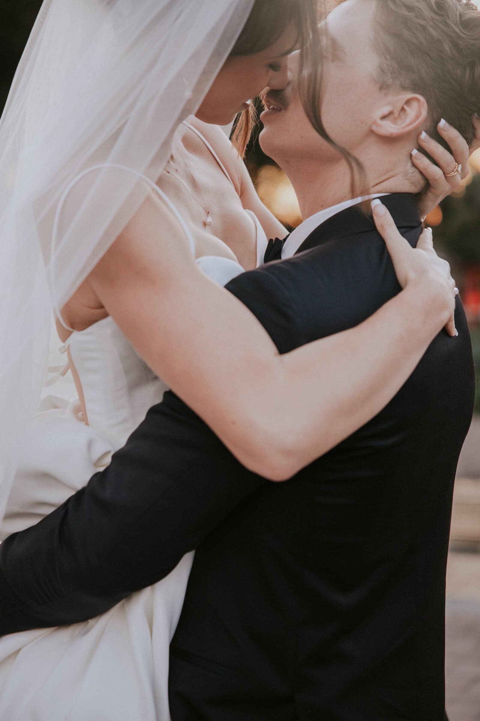 Clara and Grant kissing, her arms around his neck and her veil around them both