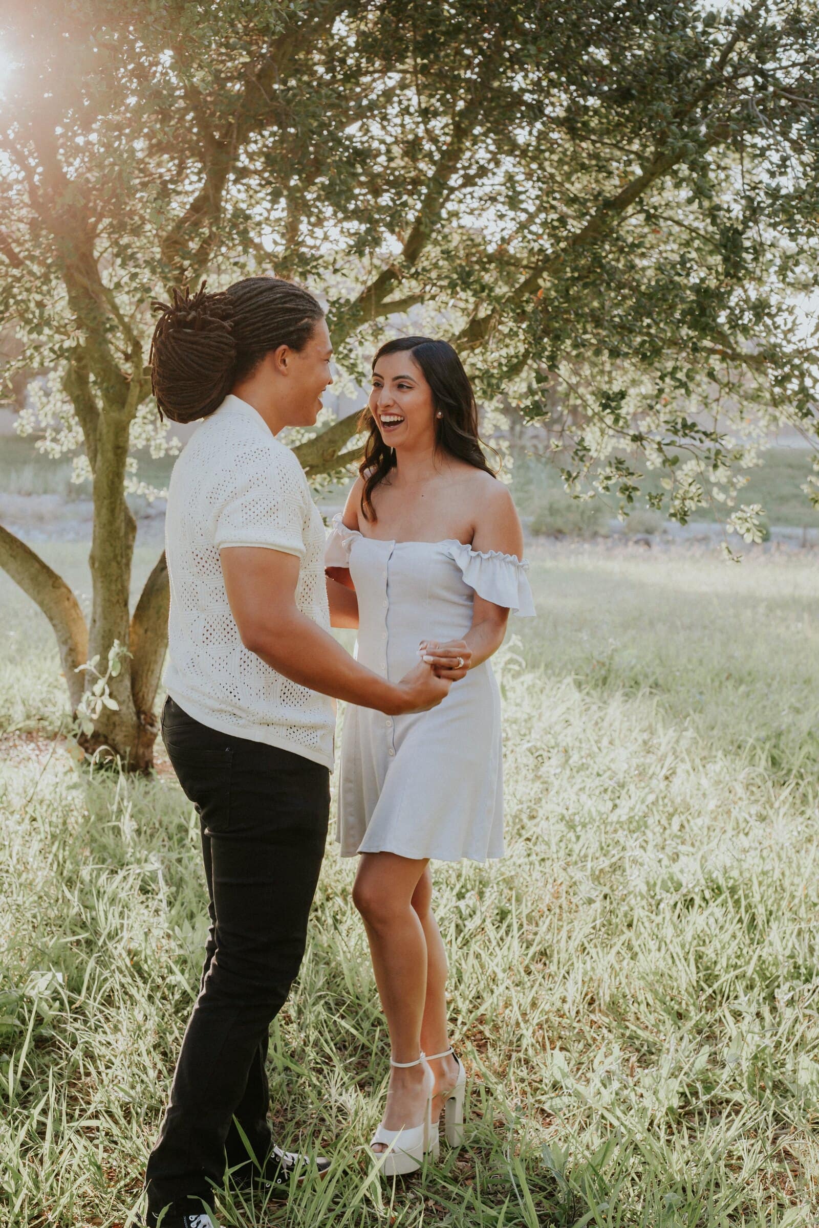 Jeremy and Ambica standing close under the oak branches