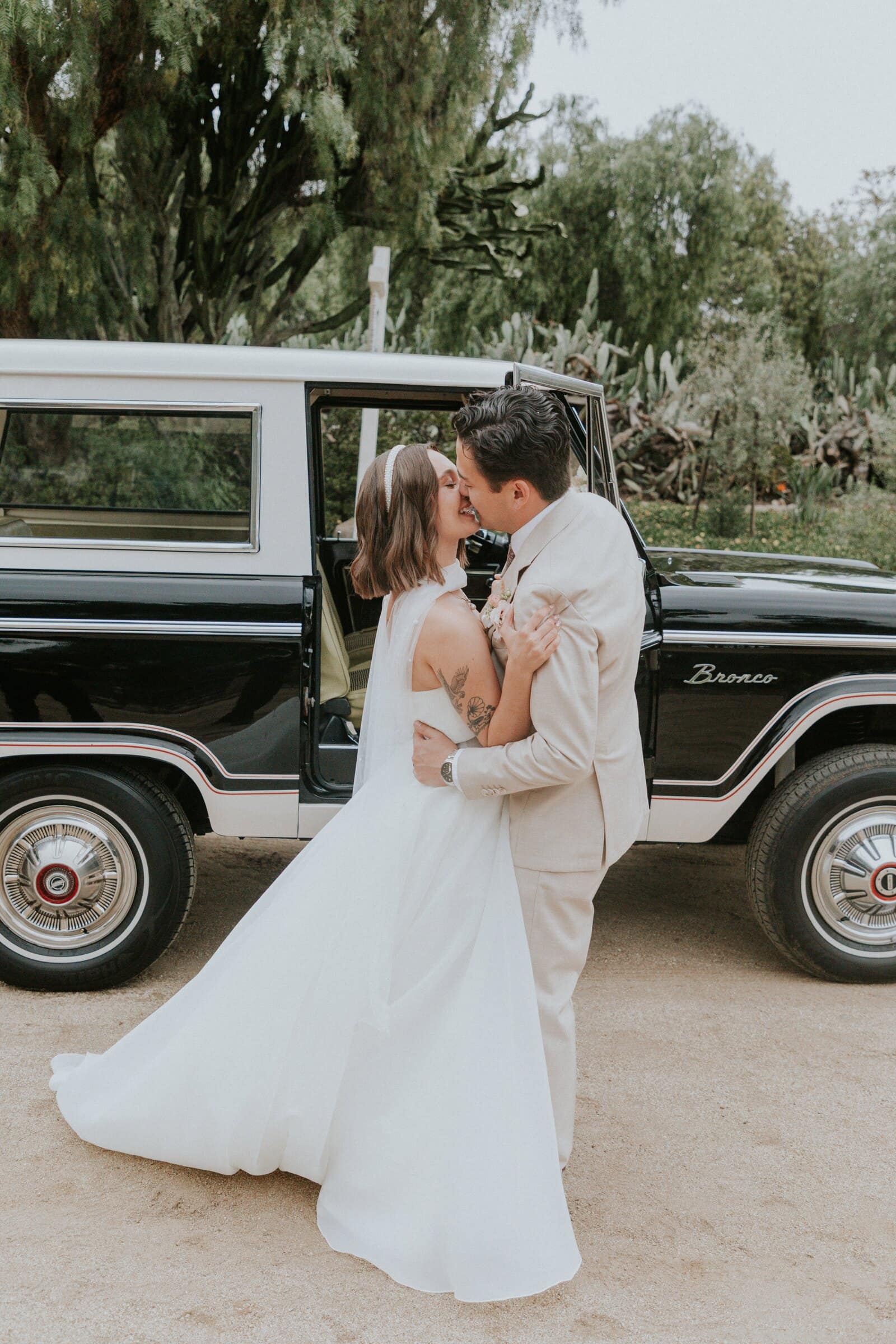 Megan and Caleb kissing beside the black Ford Bronco