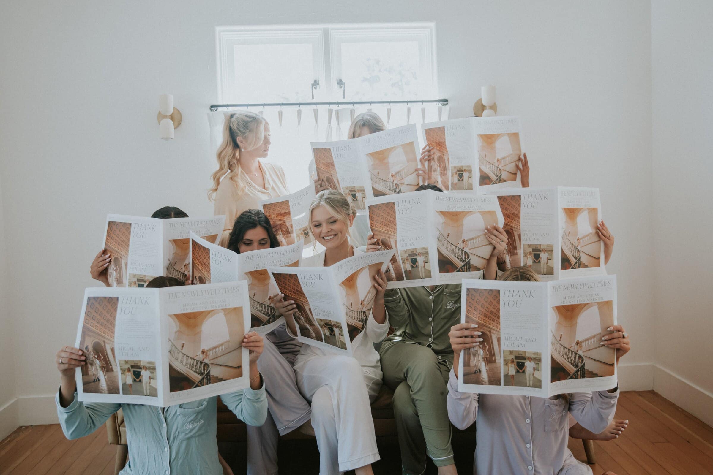 Leilani's bridesmaids hiding behind open newspapers