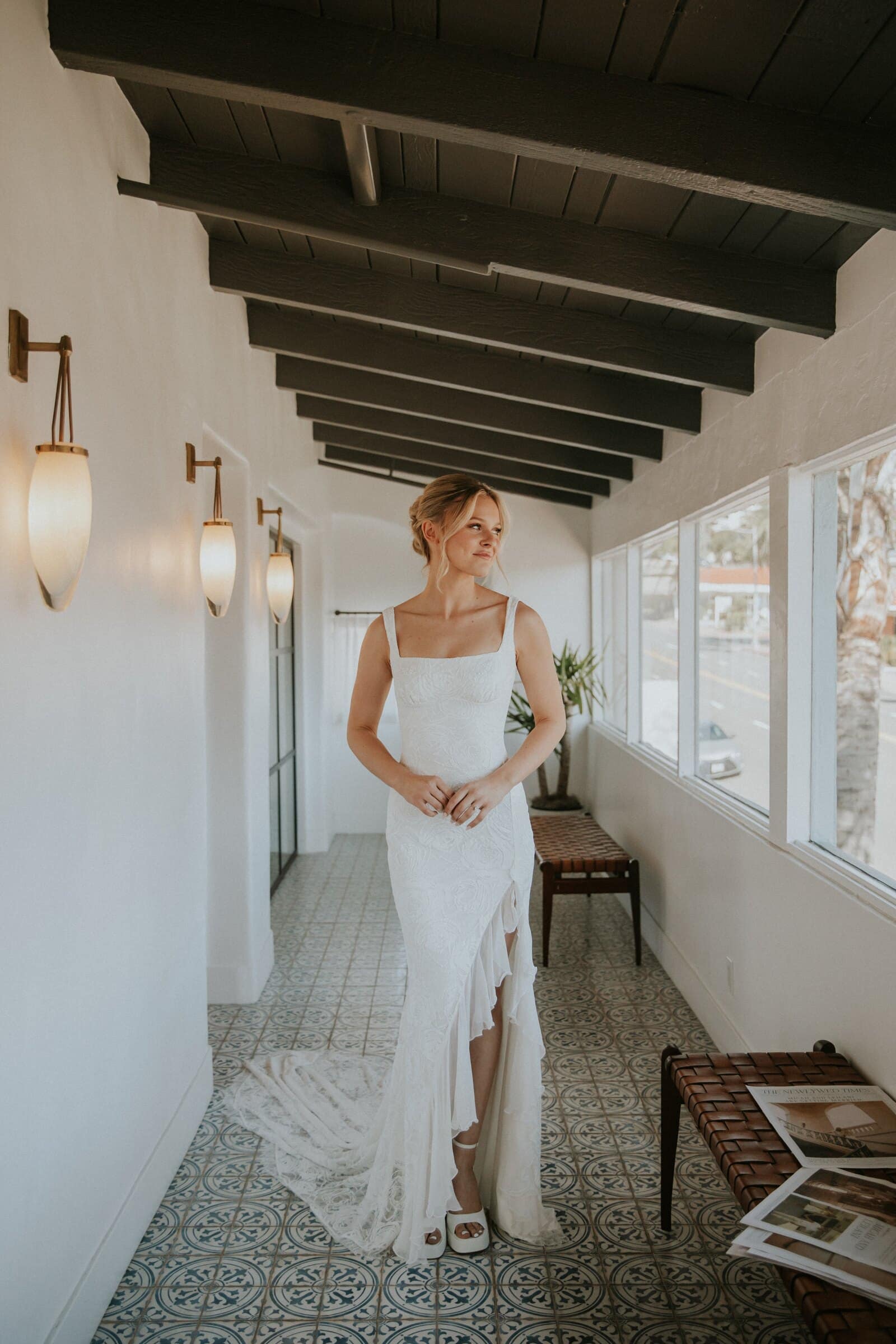 Leilani walking down a sunlit hallway in her dress
