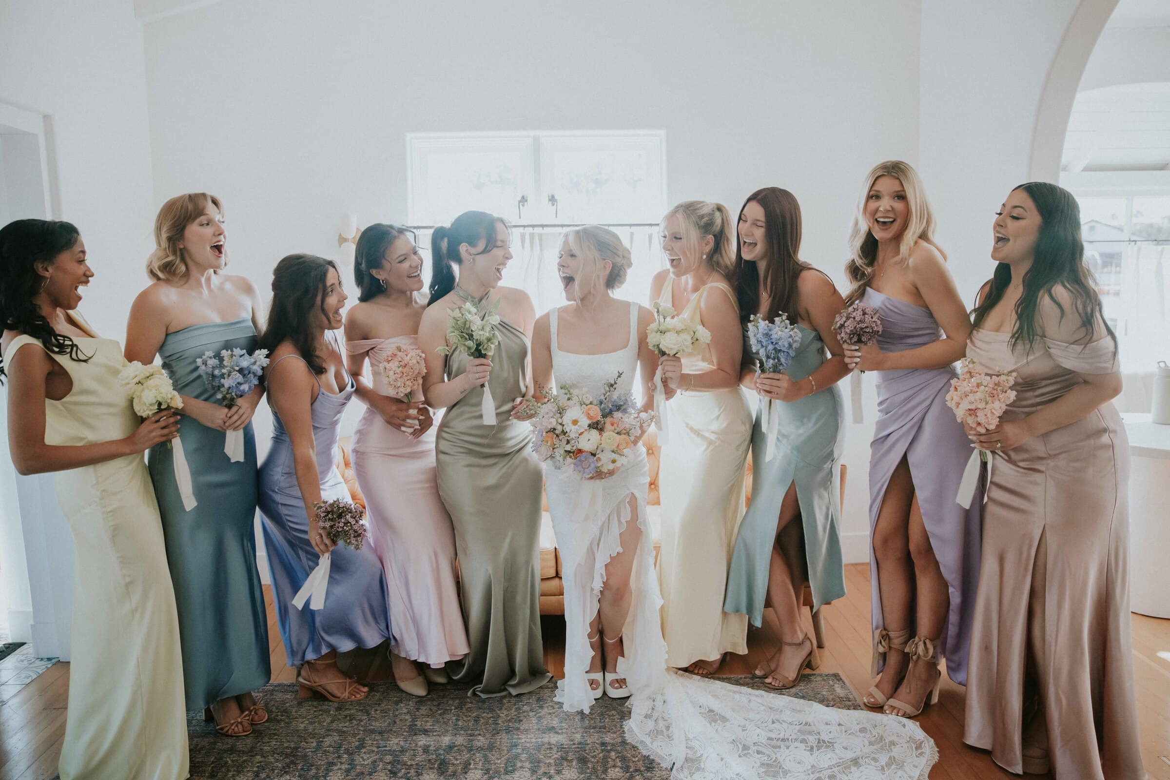 Leilani laughing with her bridesmaids in pastel dresses