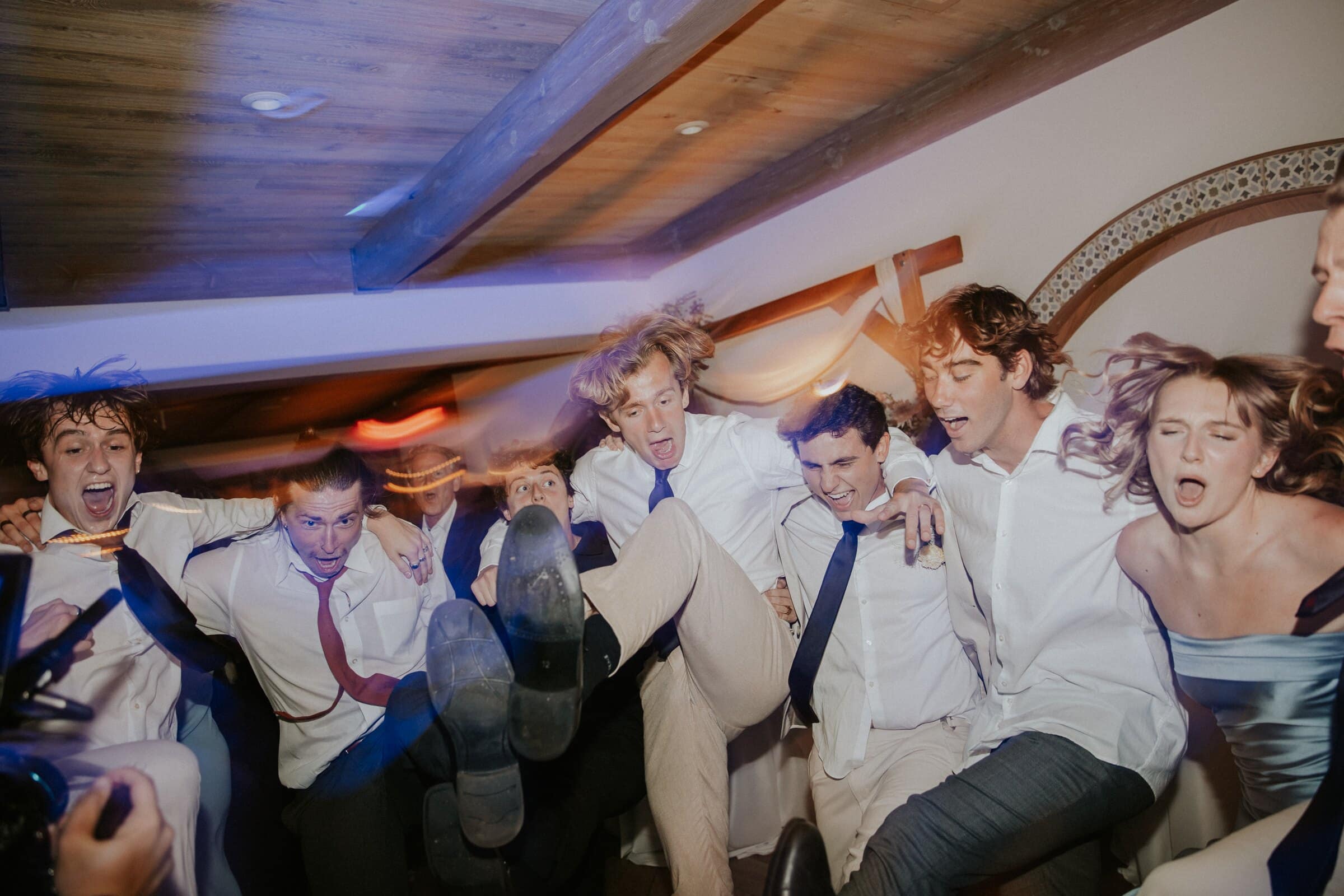 Friends piled together on the dance floor, kicking their feet up