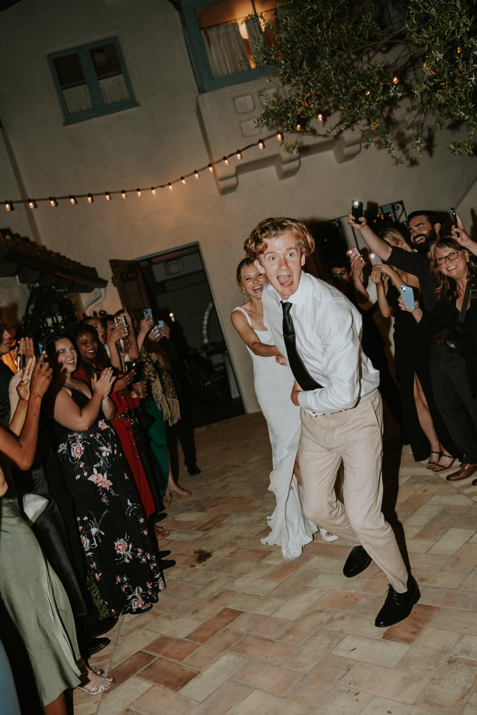 Micah dancing through the courtyard as Leilani follows at the send-off